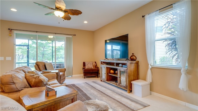 living room with a wealth of natural light, ceiling fan, and light tile patterned floors