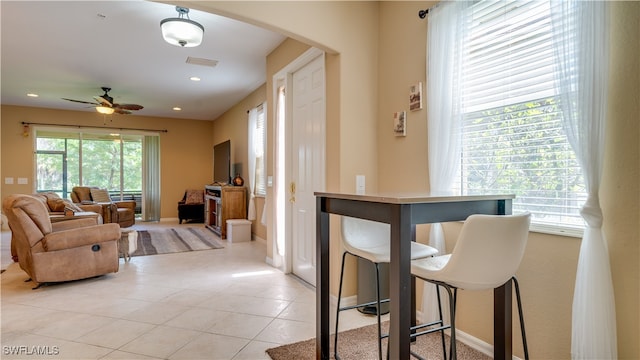 living room featuring arched walkways, light tile patterned floors, recessed lighting, a ceiling fan, and baseboards