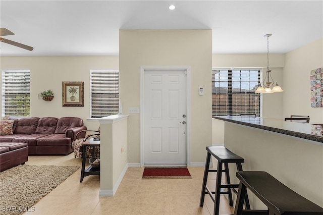 entrance foyer featuring ceiling fan with notable chandelier and light tile patterned flooring