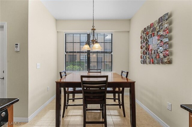 dining space with light tile patterned floors and a chandelier