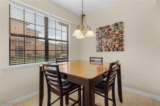 tiled dining space featuring a notable chandelier