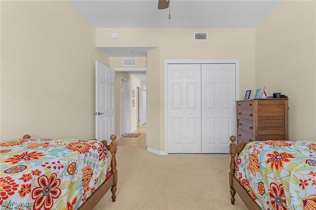 bedroom with a closet, light colored carpet, and ceiling fan