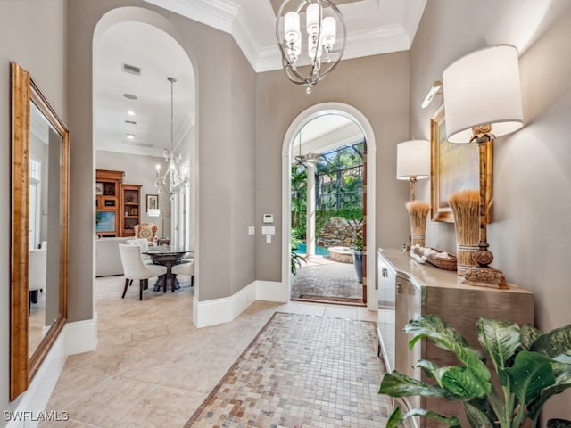 tiled foyer entrance with crown molding and an inviting chandelier