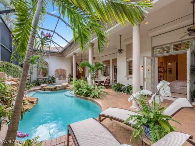 view of pool with a lanai, a patio, ceiling fan, and an in ground hot tub