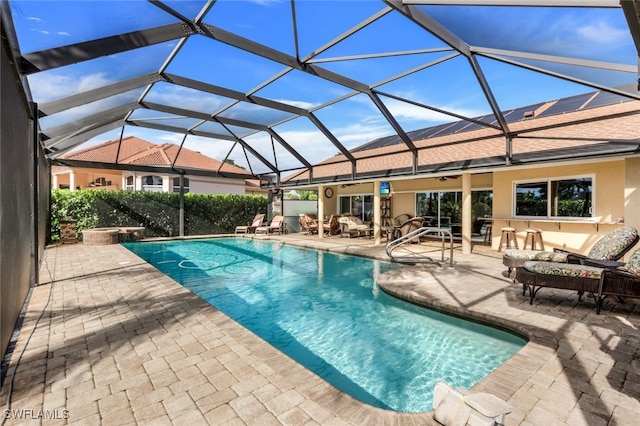 view of pool with an outdoor living space, a patio area, and glass enclosure