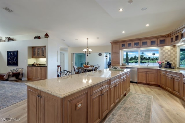 kitchen featuring a kitchen bar, a center island, pendant lighting, and light wood-type flooring