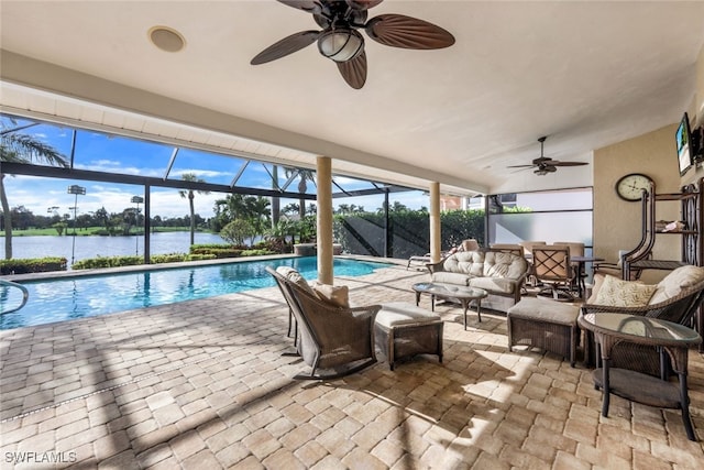 view of pool with a water view, ceiling fan, an outdoor living space, and glass enclosure