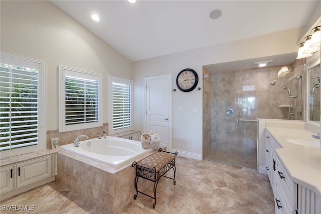 bathroom with lofted ceiling, vanity, and independent shower and bath