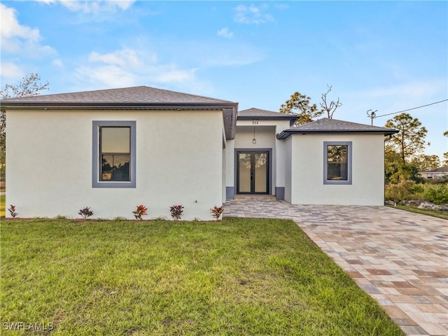 view of front of property featuring a front lawn and french doors