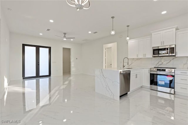 kitchen with decorative light fixtures, decorative backsplash, appliances with stainless steel finishes, and white cabinetry