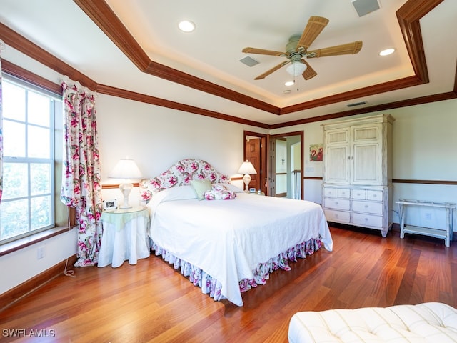 bedroom featuring hardwood / wood-style flooring, ceiling fan, crown molding, and multiple windows