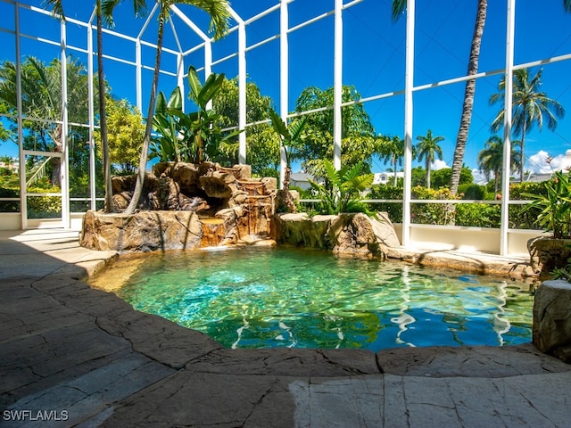 view of pool with pool water feature and a lanai