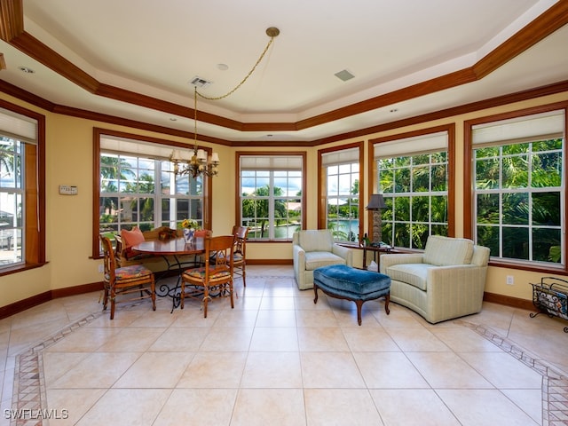 tiled dining area featuring a raised ceiling, a chandelier, a healthy amount of sunlight, and ornamental molding