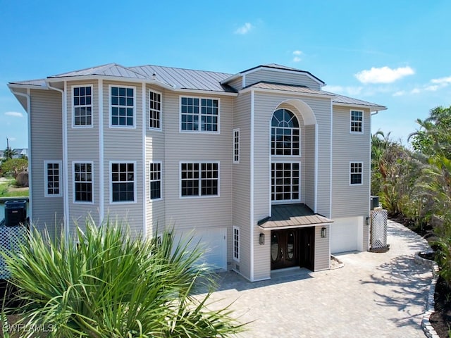 back of property with central AC and a garage