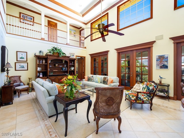 living room with light tile patterned floors, ornamental molding, and a high ceiling