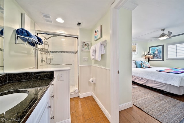 bathroom with vanity, ceiling fan, hardwood / wood-style floors, and an enclosed shower