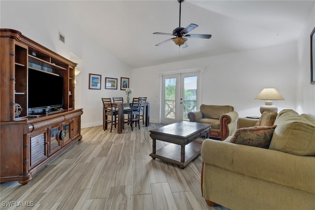 living room featuring lofted ceiling, light hardwood / wood-style flooring, ceiling fan, and french doors