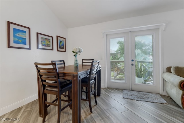 dining area with french doors and lofted ceiling