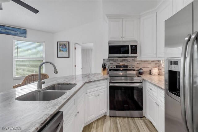 kitchen featuring backsplash, stainless steel appliances, sink, and white cabinets