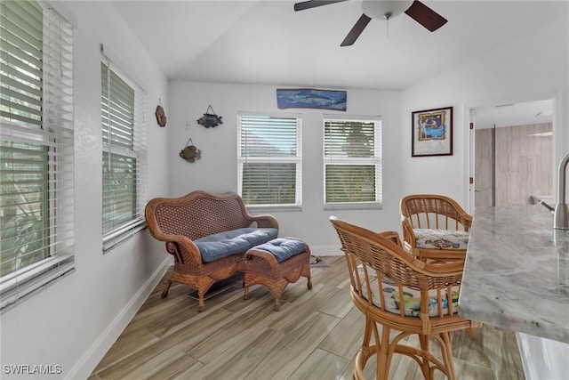 living area with ceiling fan and vaulted ceiling