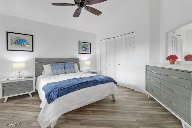 bedroom with ceiling fan, lofted ceiling, and a closet