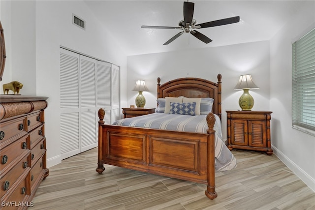 bedroom featuring lofted ceiling, light hardwood / wood-style floors, a closet, and ceiling fan