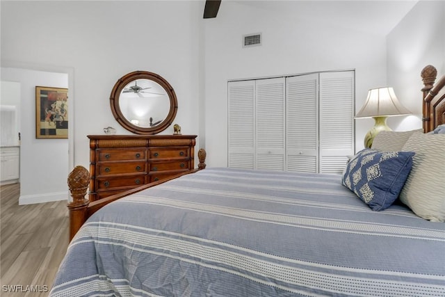 bedroom with lofted ceiling, light hardwood / wood-style floors, a closet, and ceiling fan