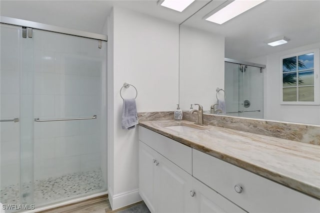 bathroom with vanity, wood-type flooring, and a shower with shower door