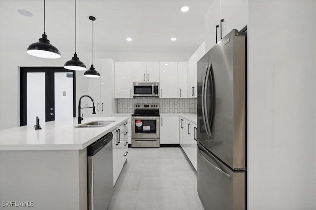 kitchen with white cabinetry, decorative backsplash, appliances with stainless steel finishes, and a sink