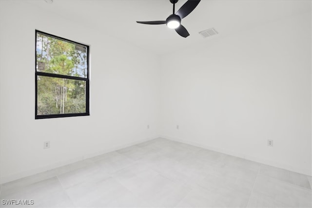 tiled spare room with ceiling fan