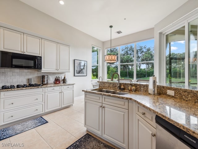 kitchen featuring a healthy amount of sunlight, stainless steel dishwasher, sink, and white cabinets