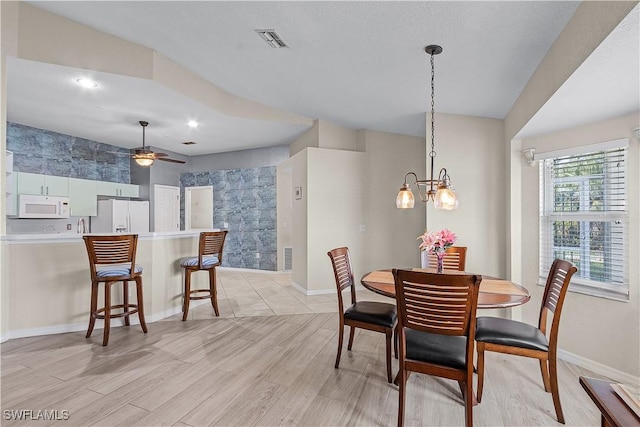 dining area featuring ceiling fan with notable chandelier and light hardwood / wood-style flooring