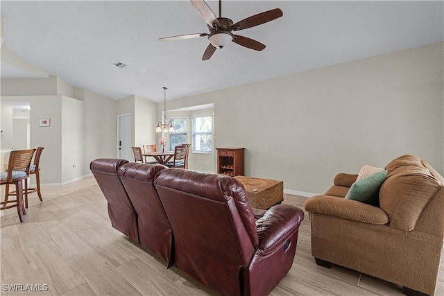 living room featuring light wood-type flooring and ceiling fan with notable chandelier