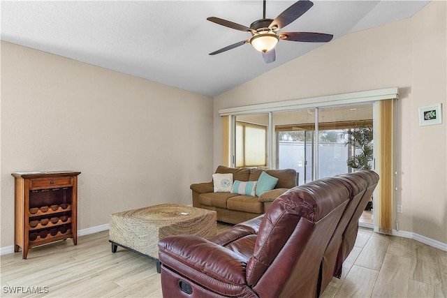 living room featuring ceiling fan, light hardwood / wood-style floors, and vaulted ceiling