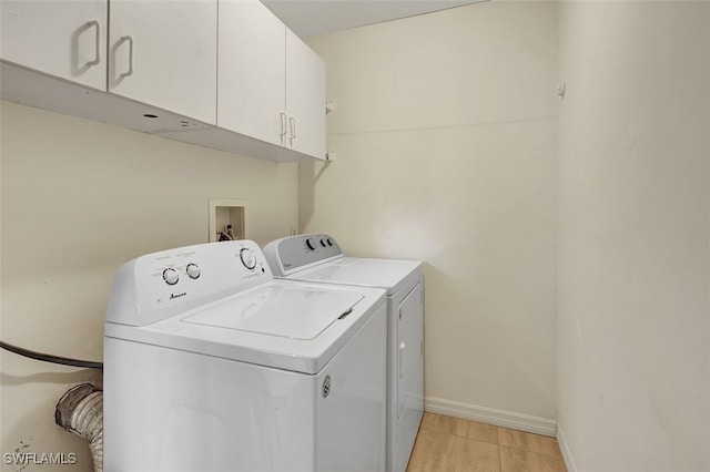 clothes washing area with cabinets and separate washer and dryer