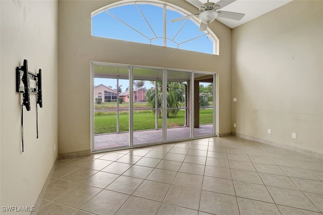 tiled spare room with high vaulted ceiling and ceiling fan