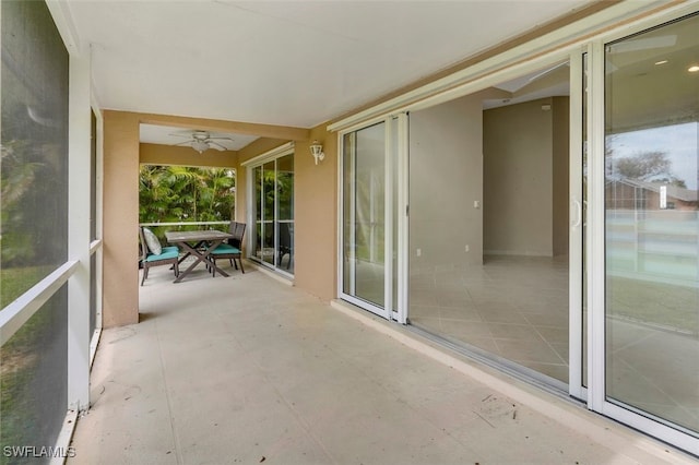 unfurnished sunroom featuring ceiling fan