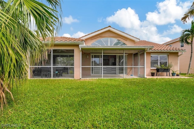 back of house with a sunroom and a yard