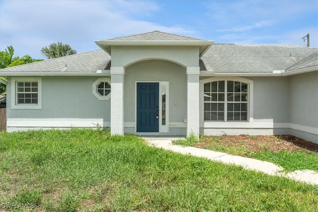 property entrance with a lawn