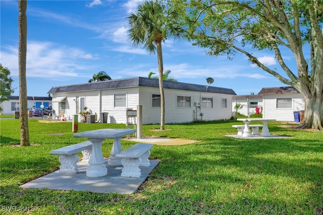 rear view of property with a yard and a patio area