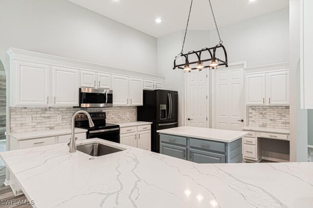 kitchen with white cabinetry, tasteful backsplash, decorative light fixtures, a kitchen island, and appliances with stainless steel finishes