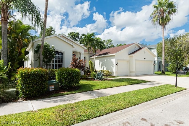 view of front of home with stucco siding, driveway, a front yard, and an attached garage