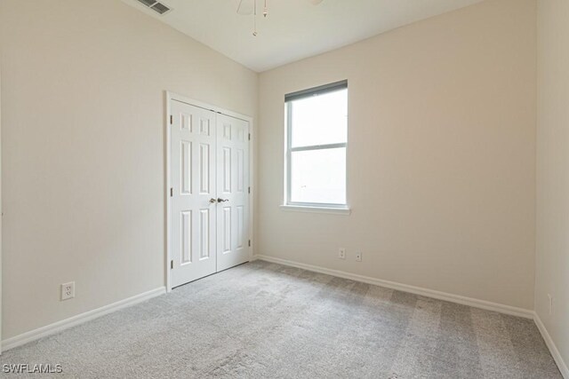 carpeted empty room featuring ceiling fan