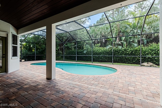 view of swimming pool with a patio area and glass enclosure