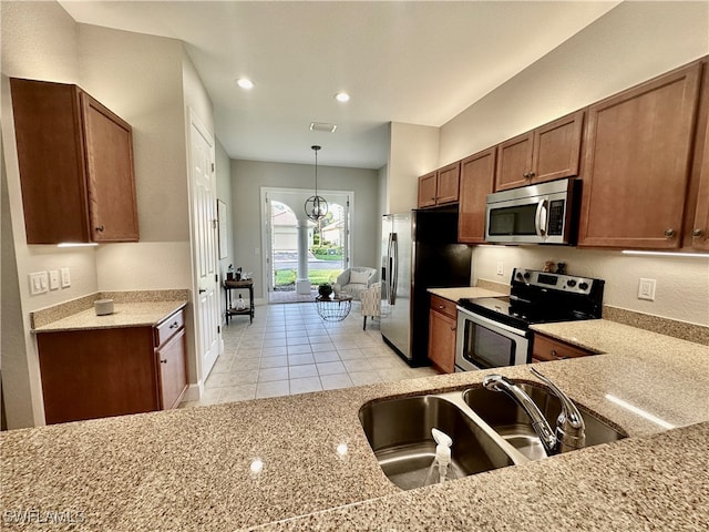 kitchen featuring stainless steel appliances, an inviting chandelier, light tile patterned floors, sink, and pendant lighting