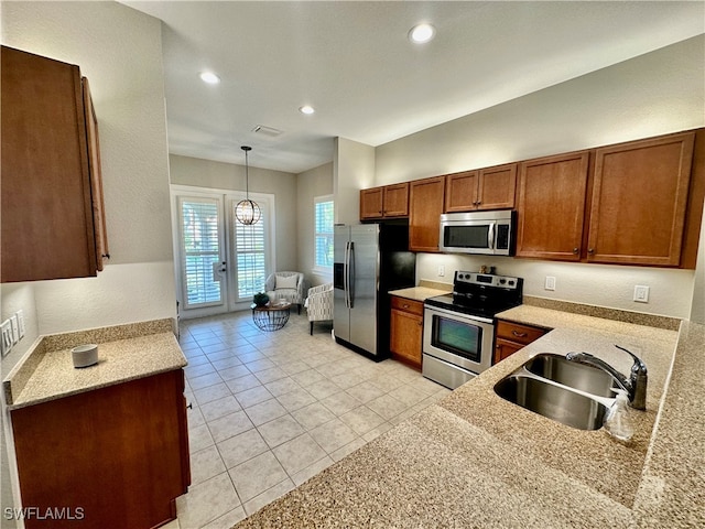 kitchen featuring french doors, stainless steel appliances, sink, light tile patterned floors, and decorative light fixtures