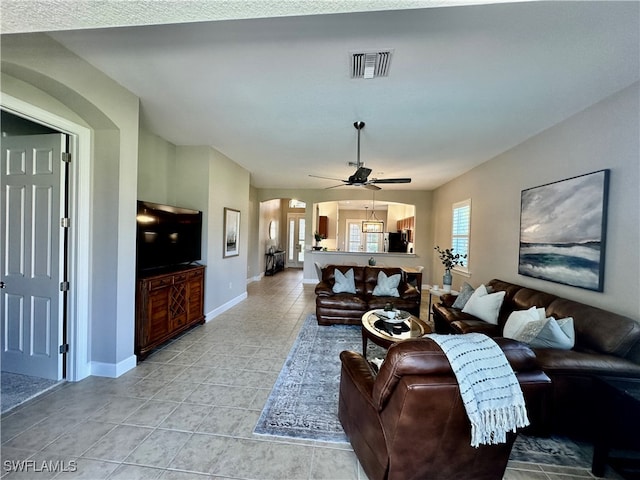 tiled living room with ceiling fan