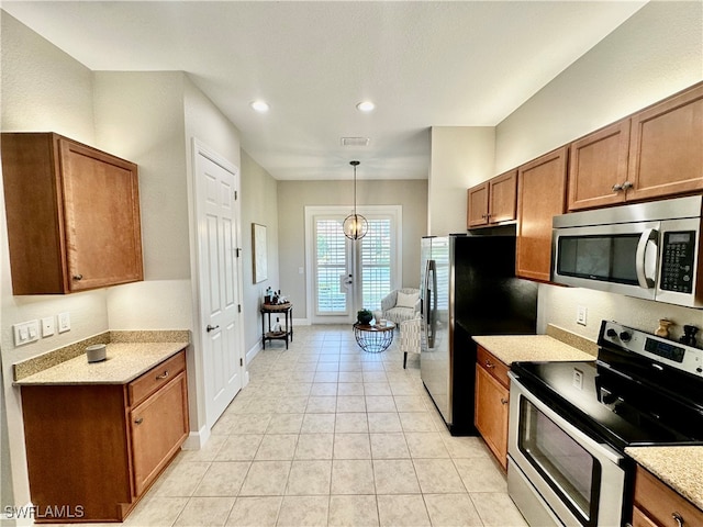 kitchen featuring appliances with stainless steel finishes, hanging light fixtures, and light tile patterned floors