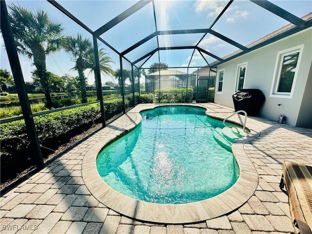 view of swimming pool with a patio area and a lanai