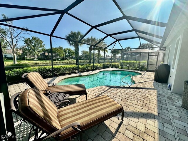 view of pool with glass enclosure and a patio